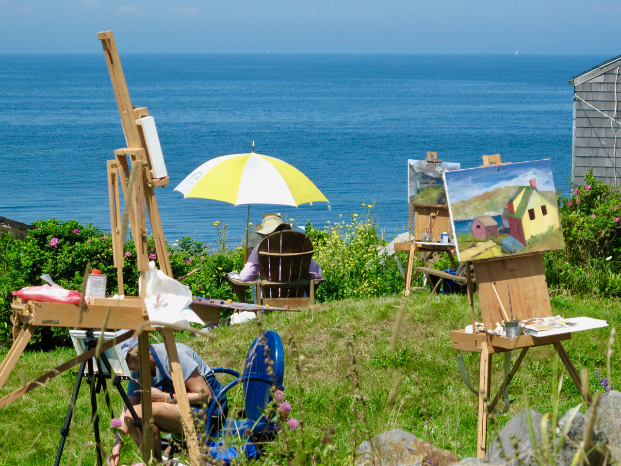 Artists set up with easels and umbrellas on Monhegan Island.